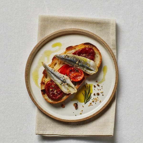 Tostada de Sardinas Calabresas con Jitomate Seco, Orégano y Nuez de Brasil