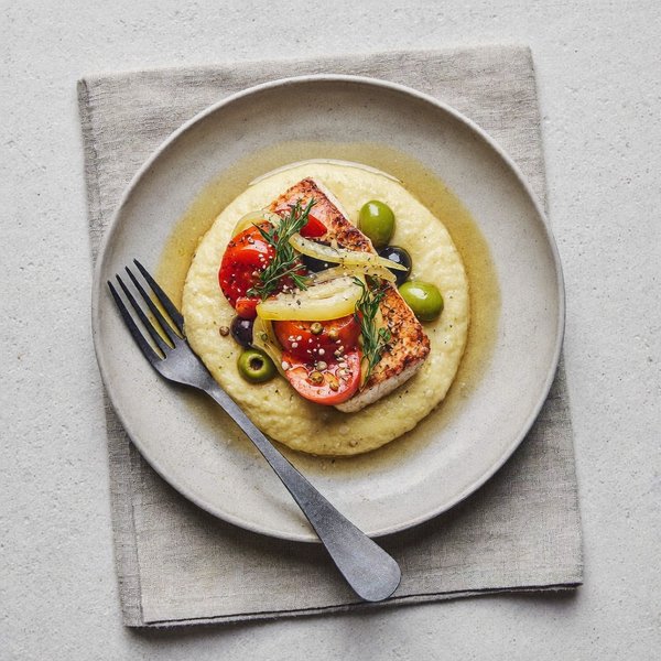 Bacalao Siciliano alla Ghiotta sobre Polenta Suave con Aceitunas, Alcaparras y Pasas