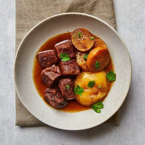 Carne de Res Chuck Cocida a Fuego Lento con Plátano Caramelizado, Especias Cálidas y Pera Guisada